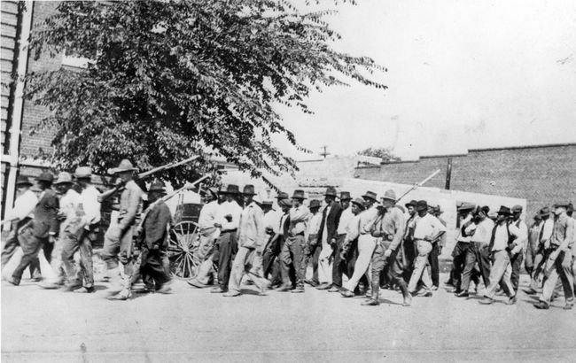 Grupa żołnierzy Gwardii Narodowej, uzbrojonych w karabiny z bagnetami, eskortuje nieuzbrojonych Murzynów do aresztu po masakrze w Tulsa Race, Tulsa, Oklahoma, czerwiec 1921 r.