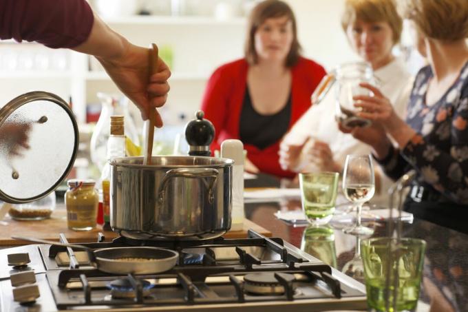 Mieszanie garnka na kuchence na wyspie kuchennej umożliwia interakcję z gośćmi.