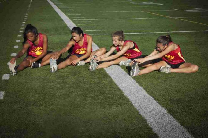 Deportistas entrenando en pista de atletismo.