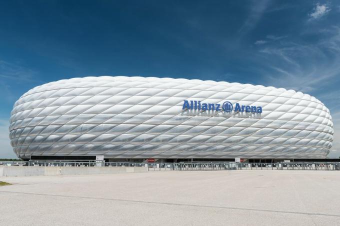 widok z boku zakrzywionego stadionu sportowego, wyrzeźbiona strona zewnętrzna z napompowanych paneli z tworzywa ETFE, wyglądająca jak biała bieżnikowana opona na boku