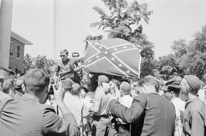 Podczas zamieszek Ole Miss studenci podnoszą flagę Konfederacji w powietrze.