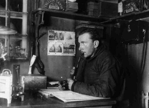 Alfred Wegener pracujący przy biurku, czarno-białe zdjęcie.