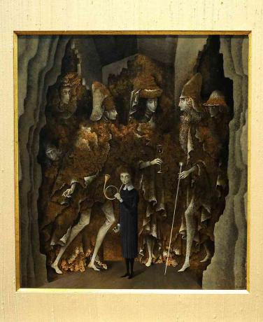 Kobieta stoi w czarnej sukience z kołnierzykiem i wieje w róg, gdy z jaskiń za jej plecami wyłania się sześć postaci