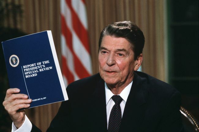 Prezydent Ronald Reagan trzymający kopię raportu Komisji Wieży w sprawie skandalu Iran-Contra
