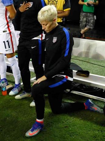 Zdjęcie kobiecej gwiazdy piłki nożnej Megan Rapinoe klęczącej podczas hymnu narodowego