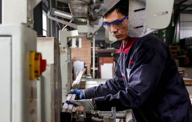 Pracownik pracujący przy wyrobach aluminiowych w fabryce w Zouping we wschodniej chińskiej prowincji Shandong