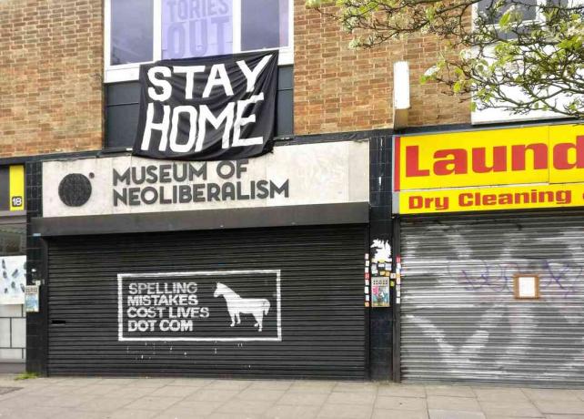 Duży znak STAY HOME nad zamkniętym Muzeum Neoliberalizmu w Lewsiham, Londyn, Anglia.